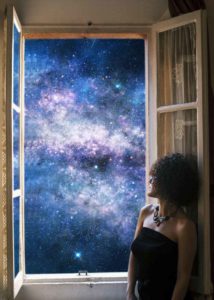 woman at the window is watching a starry sky